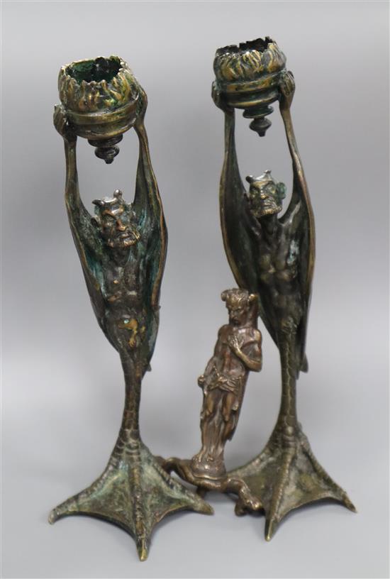 A pair of cast bronze candlesticks and another similar figure